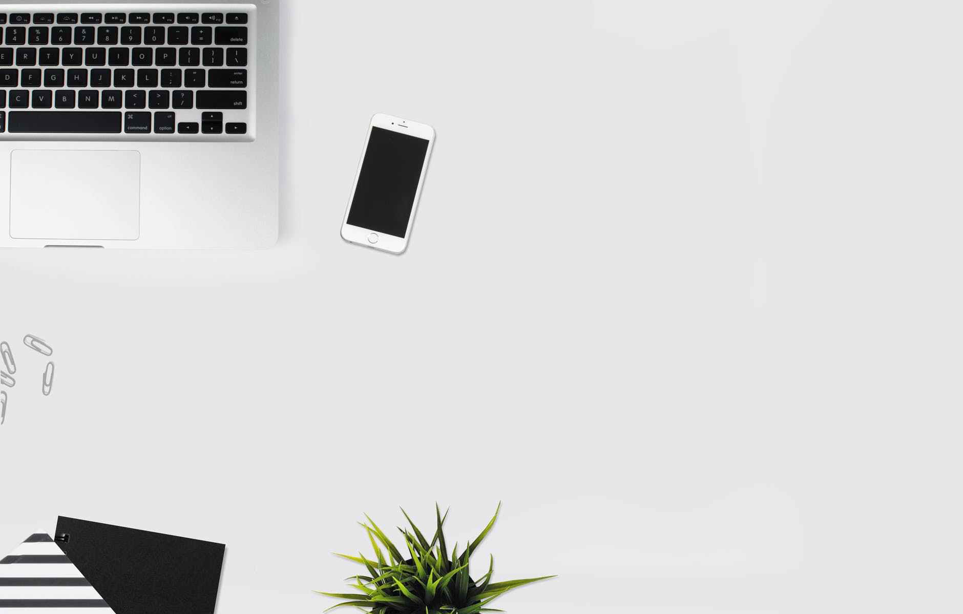 white smartphone beside silver laptop computer
